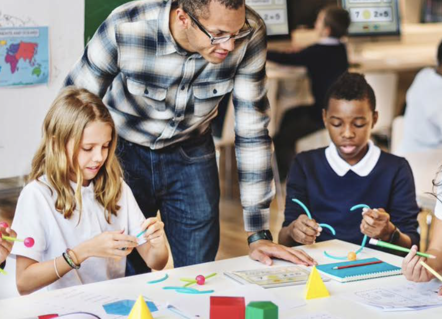 Teacher with students e1767224128509